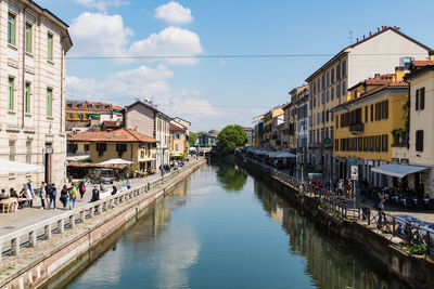 Canal amidst buildings in city against sky