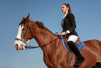 Portrait of man riding horse on field