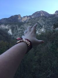 Low section of woman on mountain against clear sky