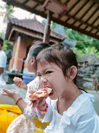 Portrait of girl eating food outdoors