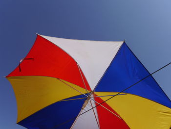 Low angle view of umbrella against blue sky