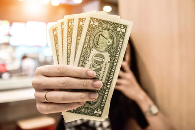 Close-up of woman holding dollar bills