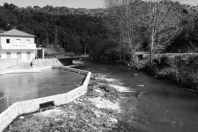 Swimming pool by river against sky