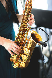 Midsection of woman playing saxophone at music concert