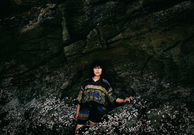 Portrait of woman sitting on rock