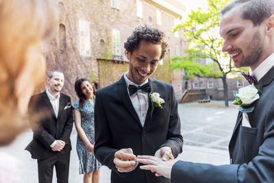 Gay couple exchanging rings during wedding ceremony