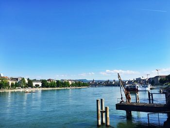 Scenic view of river by city against clear blue sky