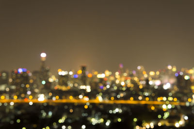 Defocused image of illuminated city buildings at night