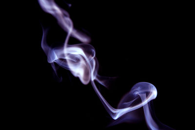 Close-up of purple smoke against black background