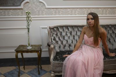 Portrait of woman sitting on sofa