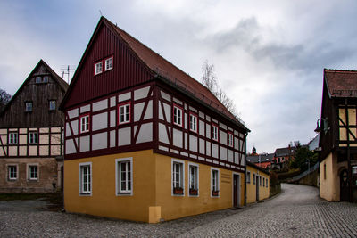 Residential building by road against sky