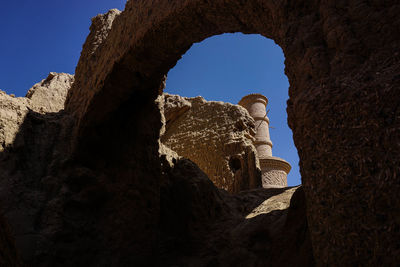 Low angle view of rock formation against clear blue sky