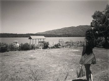 Woman standing by sea against clear sky