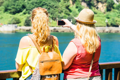 Rear view of woman photographing outdoors