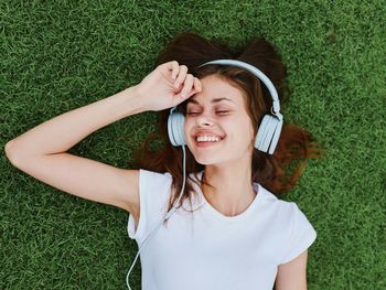 Portrait of young woman lying on grassy field