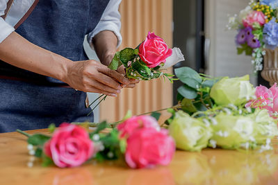 Midsection of man holding rose bouquet