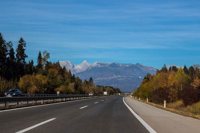 Road amidst trees against sky