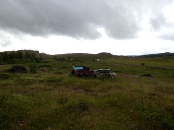 Horse cart on field against sky