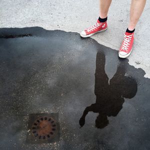 Low section of woman standing in puddle