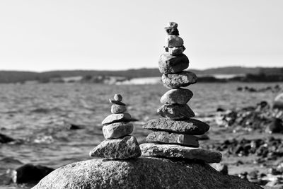 Stack of stones on rock against sky