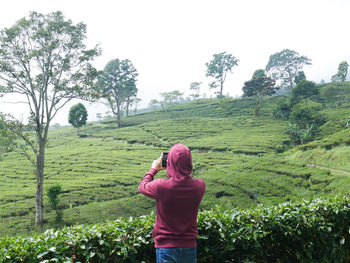 Rear view of woman standing on field