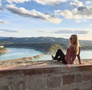 Woman sitting on rock looking at view