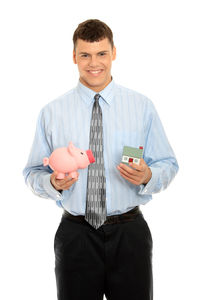 Portrait of smiling man holding camera against white background