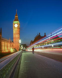 Light trails on westminster bridge by big ben in city at night