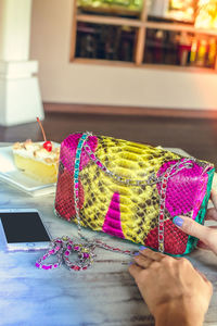 High angle view of woman holding multi colored cake