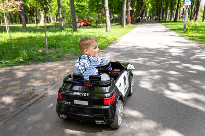 Boy riding electric toy car on road