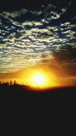 Scenic view of silhouette landscape against orange sky