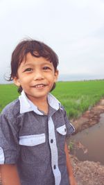 Smiling boy standing on field