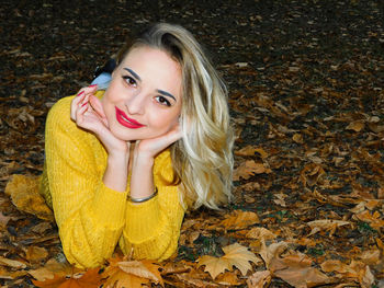 Portrait of a smiling young woman in autumn leaves