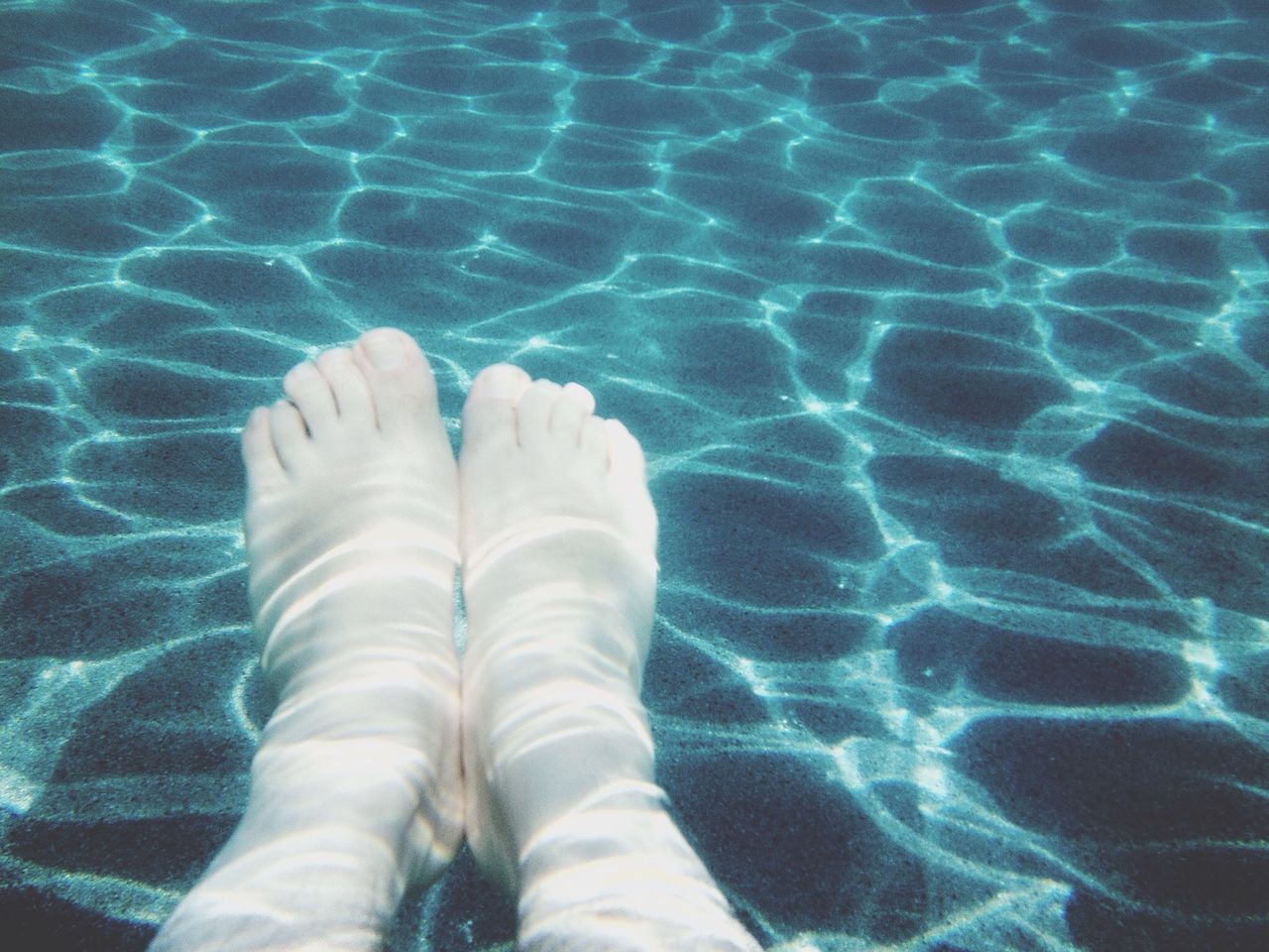 low section, person, high angle view, personal perspective, part of, water, pattern, human foot, close-up, unrecognizable person, indoors, blue, sunlight, shadow, shoe, day