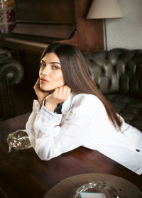 Young woman sitting on sofa at home