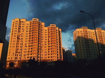 Low angle view of buildings against cloudy sky