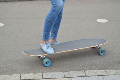 Skateboarder, skateboarding female feet in the skatepark.