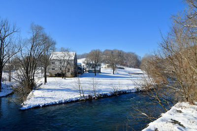 Scenic view of frozen lake against clear blue sky