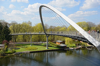 Ferris wheel by bridge against sky