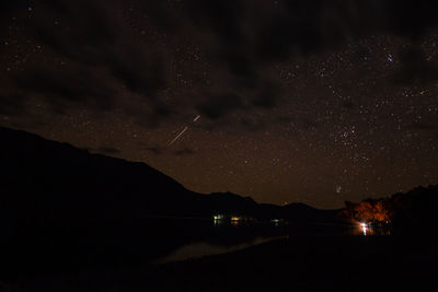 Scenic view of lake against sky at night