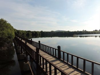 Bridge over calm lake against sky