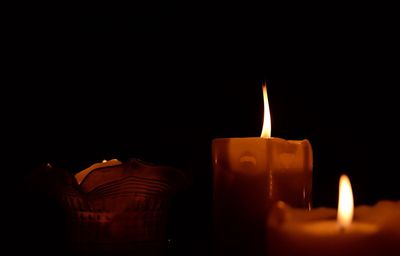 Close-up of lit candles in darkroom