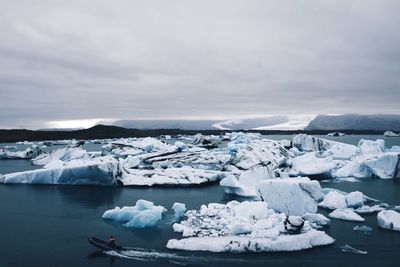 Frozen lake against sky during winter