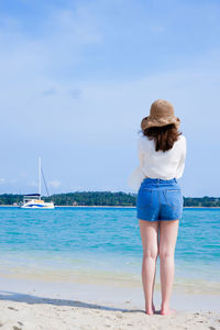 Rear view of woman standing at beach