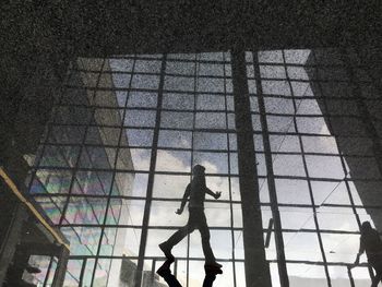 Reflection of man on tiled floor in building