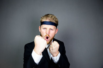 Portrait of man wearing mask against gray background