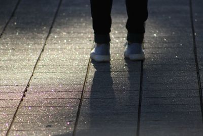 Low section of woman standing on tiled floor