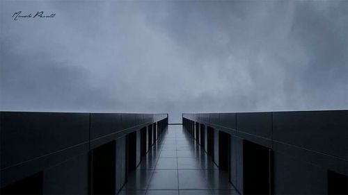 Low angle view of modern building against cloudy sky