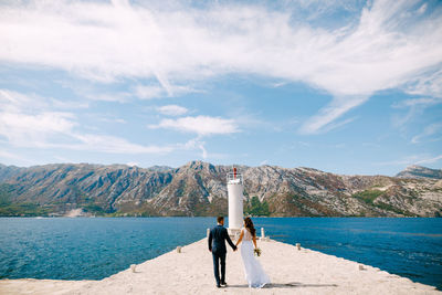 Rear view of woman in sea against mountains