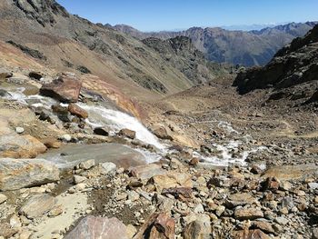 Scenic view of river by mountains against sky